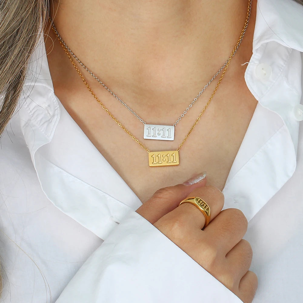 Gold and silver Divine Timing 11:11 stainless steel necklaces layered together on a model wearing a white blouse.
