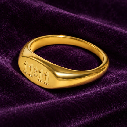 Gold finish stainless steel Divine Timing 11:11 ring displayed on deep purple velvet
